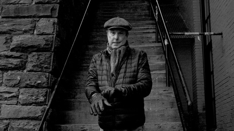 Un hombre se abriga con sus guantes en las escaleras de la ciudad.
