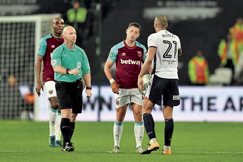 El árbitro muestra una tarjeta amarilla a un jugador del West Ham
