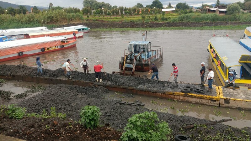 Trabajadores retiran el lodo de un canal en Xochimilco