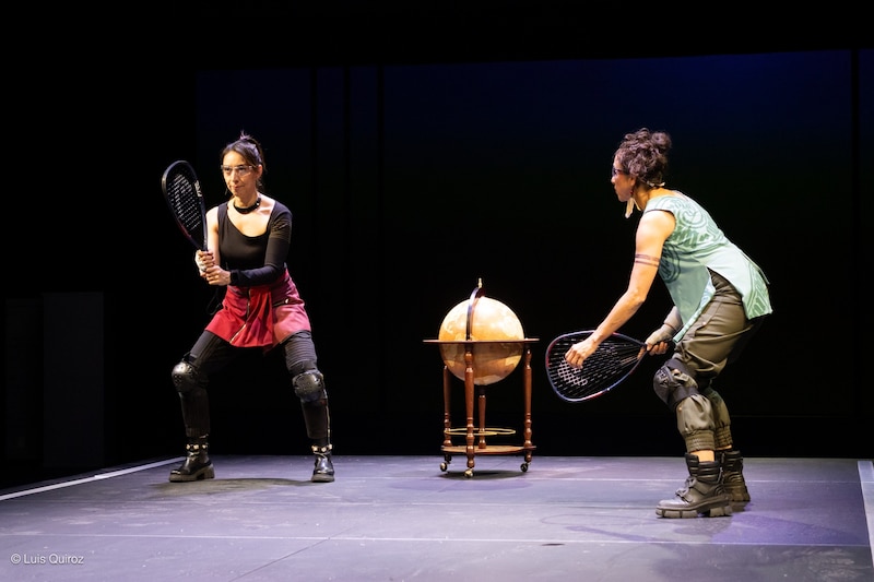 Dos mujeres juegan al tenis en un escenario.