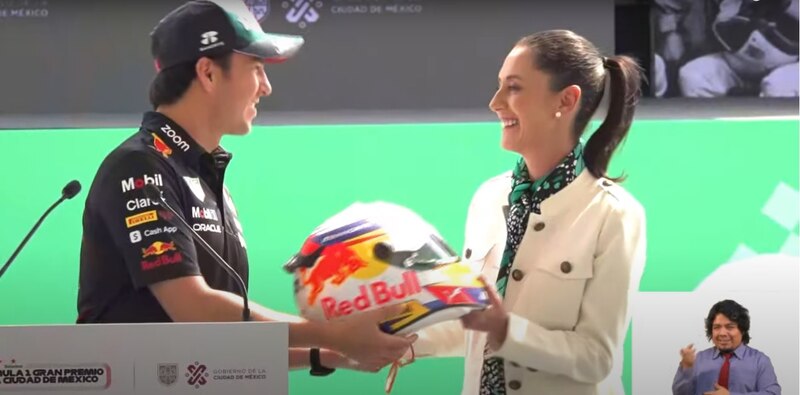 El piloto mexicano Sergio Pérez recibe un casco conmemorativo de manos de la Jefa de Gobierno de la Ciudad de México, Claudia Sheinbaum.