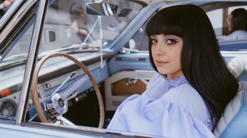 Cantante Rosalía en un coche clásico