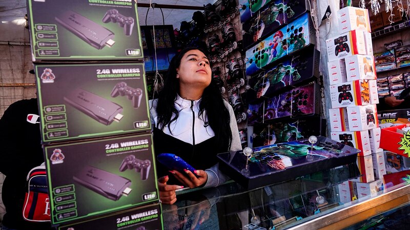 Mujer mirando videojuegos en un puesto de mercado