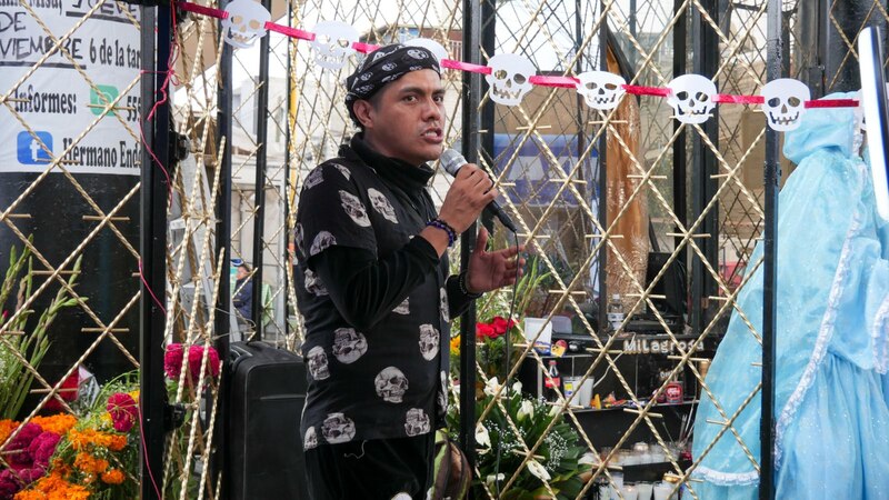 Un hombre canta frente a una estatua de la Virgen de Guadalupe