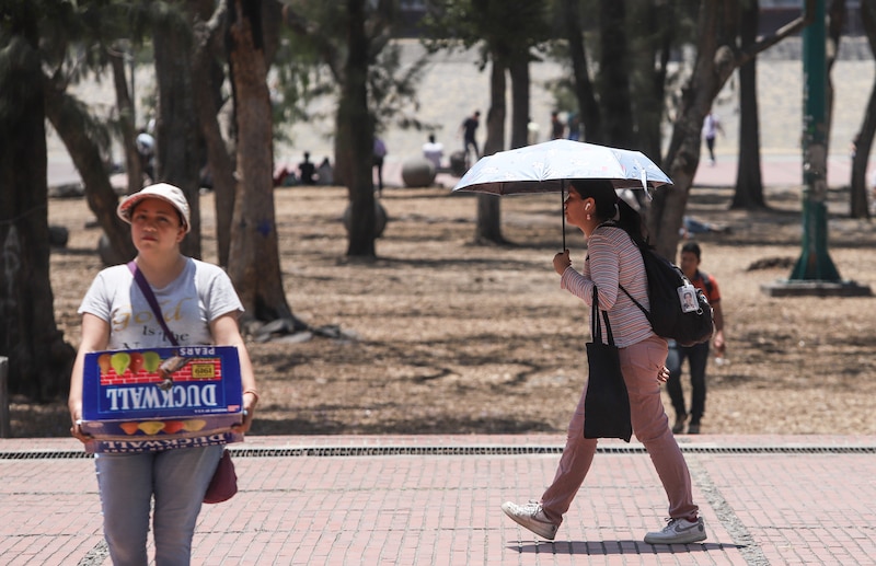 Mujer caminando por la calle en un día soleado