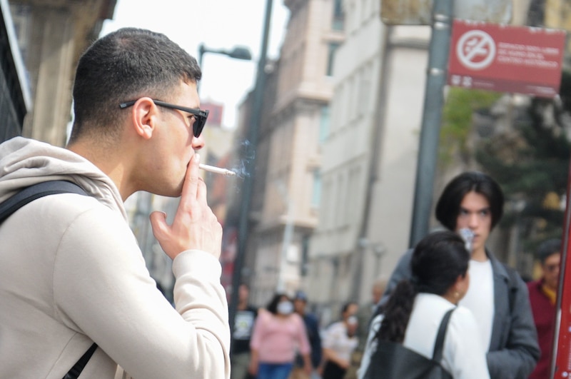 Un hombre fumando en la calle