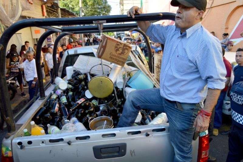 Un hombre en la parte trasera de una camioneta llena de botellas de cerveza.