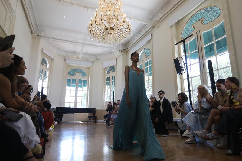 Un desfile de modas en una sala con una modelo en primer plano