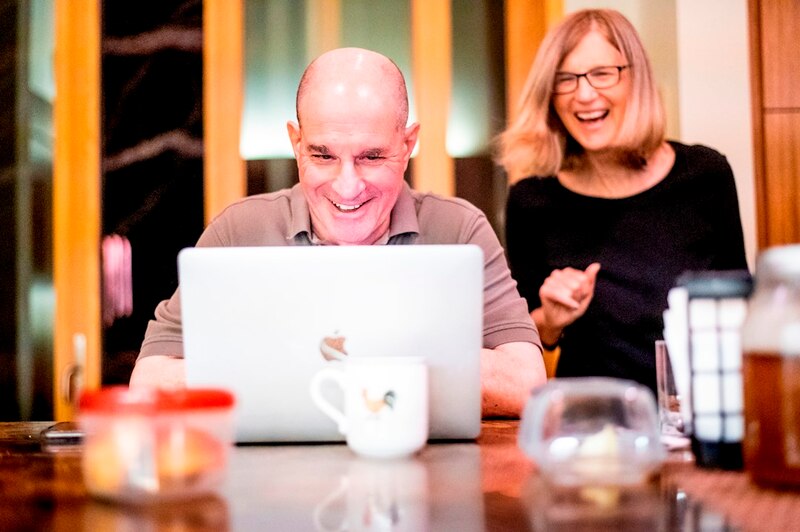 Pareja de mediana edad usando una computadora portátil en la cocina