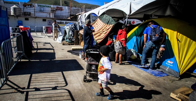 Un niño camina entre tiendas de campaña en un campamento de refugiados.