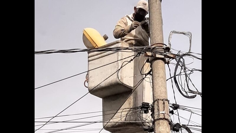Un trabajador de la compañía eléctrica arregla un poste de luz