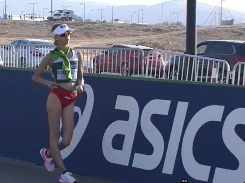Mujer atleta de alto rendimiento en plena competencia de marcha atlética.