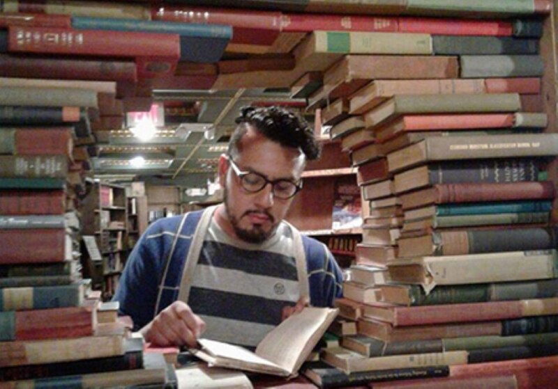 Un hombre leyendo un libro en una biblioteca