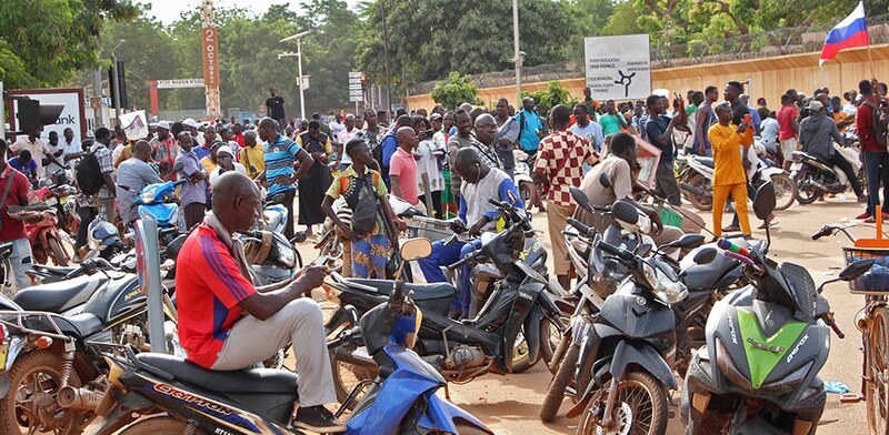 Hombres en motocicletas esperan en una calle en África