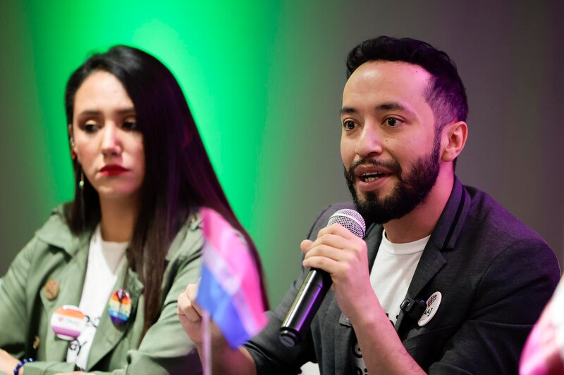 Un hombre y una mujer están sentados uno al lado del otro en una conferencia.