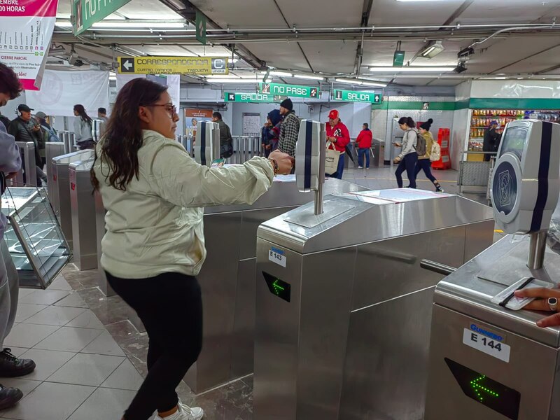 Mujer usando su teléfono para pagar el metro