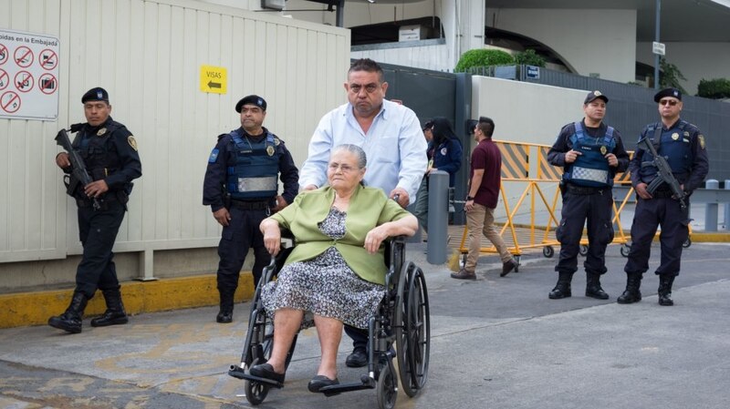 Anciana en silla de ruedas es escoltada por policías