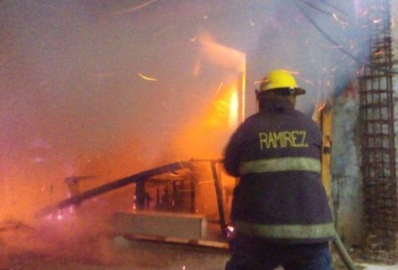 Bombero apaga incendio en una casa