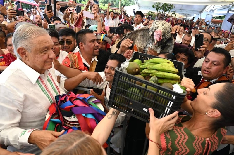 El presidente ecuatoriano Guillermo Lasso es recibido con una ofrenda de frutas y un pavo durante una visita a un mercado en Quito.