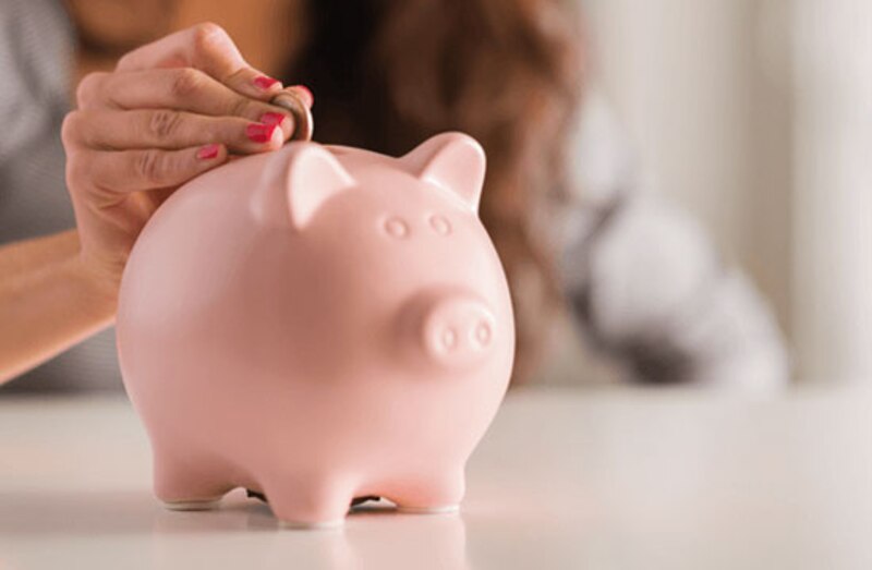 Mujer ahorrando dinero en una alcancía.