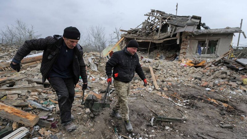 Soldados ucranianos caminan entre los escombros de una casa destruida en Kiev