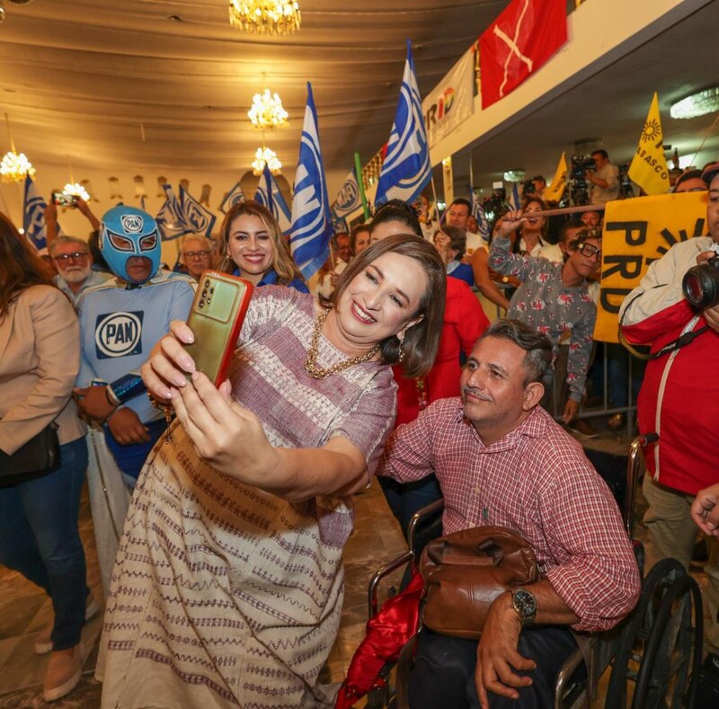 La candidata del PAN, Josefina Vázquez Mota, se toma una foto con un simpatizante en silla de ruedas durante un evento de campaña.