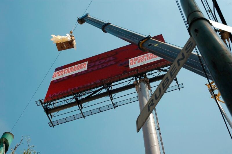 Una grúa retira un cartel publicitario de una valla publicitaria.