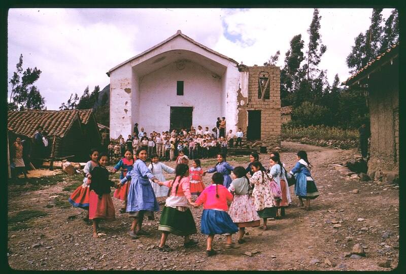 Niñas indígenas bailando en círculo en un pueblo de los Andes