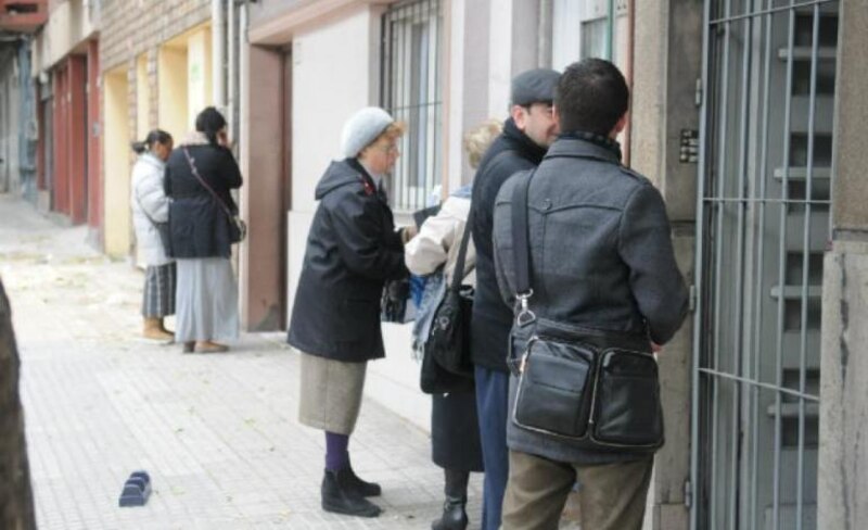 La gente espera en la cola para entrar en un edificio.