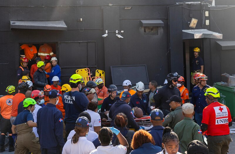 Integrantes del cuerpo de bomberos y de rescate evacúan a un herido este martes, en la discoteca Jet Set en Santo Domingo (República Dominicana). El número de muertos por el desplome del techo de una popular discoteca de la capital dominicana se eleva por el momento a 18, mientras que los heridos superan el centenar y hay una cifra indeterminada de personas atrapadas entre los escombros, según los últimos datos provisionales del Centro de Operaciones de Emergencias