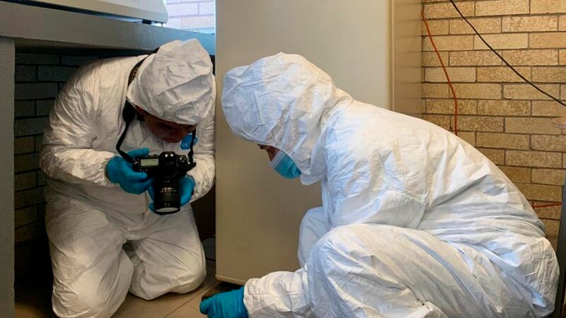 Investigadores forenses recogiendo pruebas en la escena de un crimen