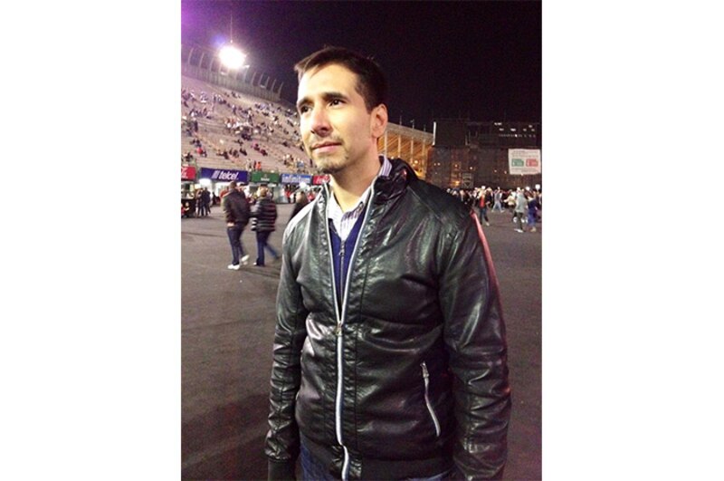 Un hombre con chaqueta de cuero en un estadio de fútbol.
