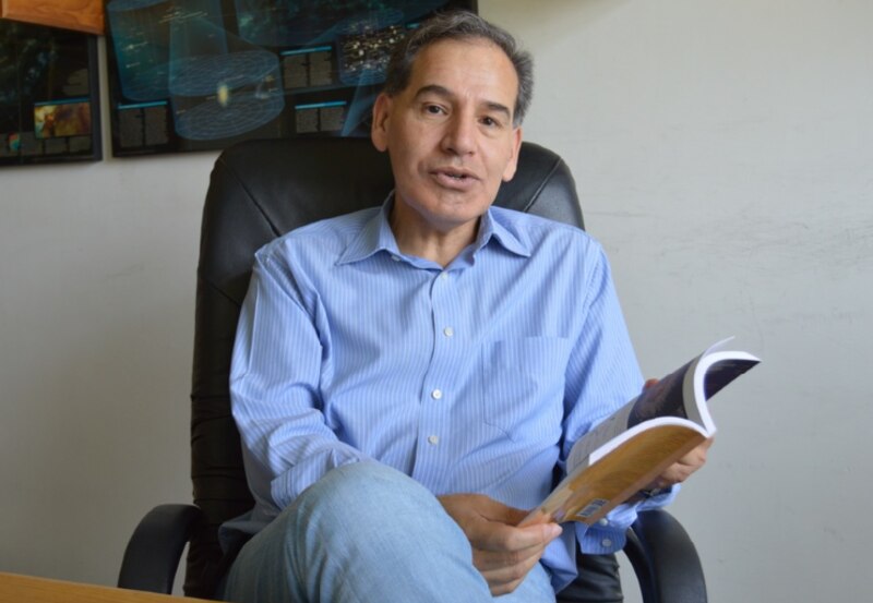 El Dr. Juan Pérez, un científico de renombre mundial, lee un libro.