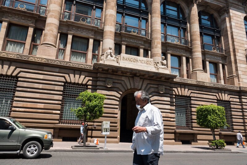 Un hombre camina frente al Banco de México
