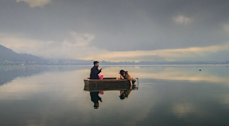 Pareja en bote en lago con niebla