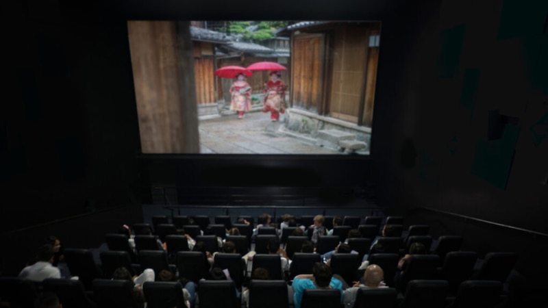 Una imagen de una sala de cine con gente sentada viendo una película.