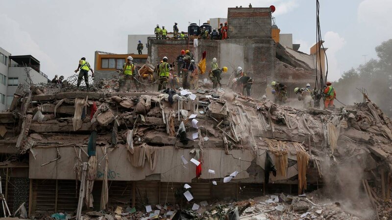Rescatistas buscan sobrevivientes entre los escombros de un edificio colapsado