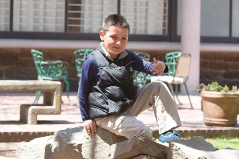 Niño discapacitado sentado en una piedra