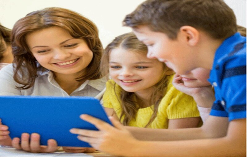 Profesora con alumnos mirando una tablet