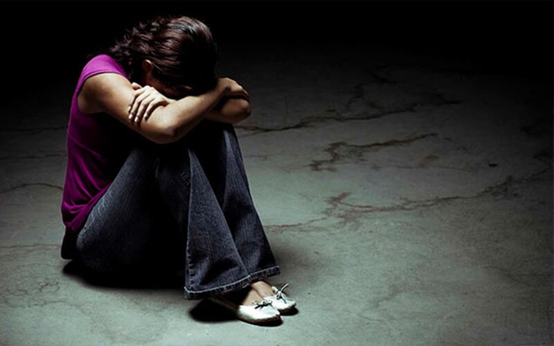 Mujer triste sentada en el suelo
