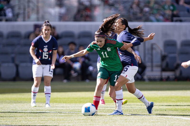 Jugadora de fútbol mexicana dribla a una jugadora del equipo contrario