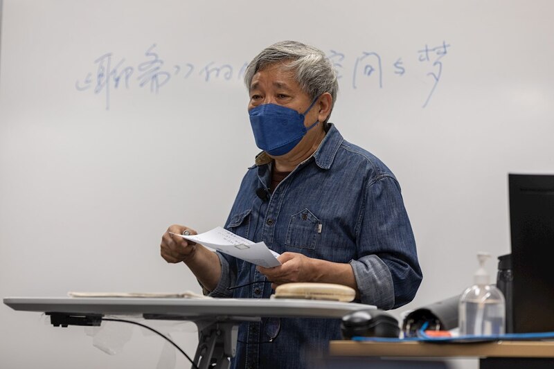 Profesor asiático con mascarilla en clase