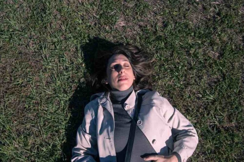Mujer tomando el sol en el pasto