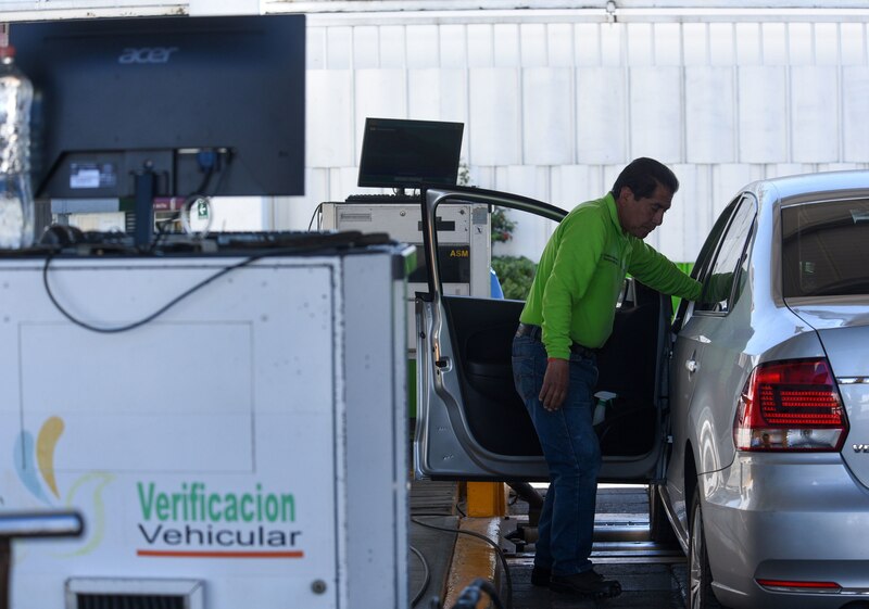 Un hombre realiza la verificación vehicular en una Ciudad de México.