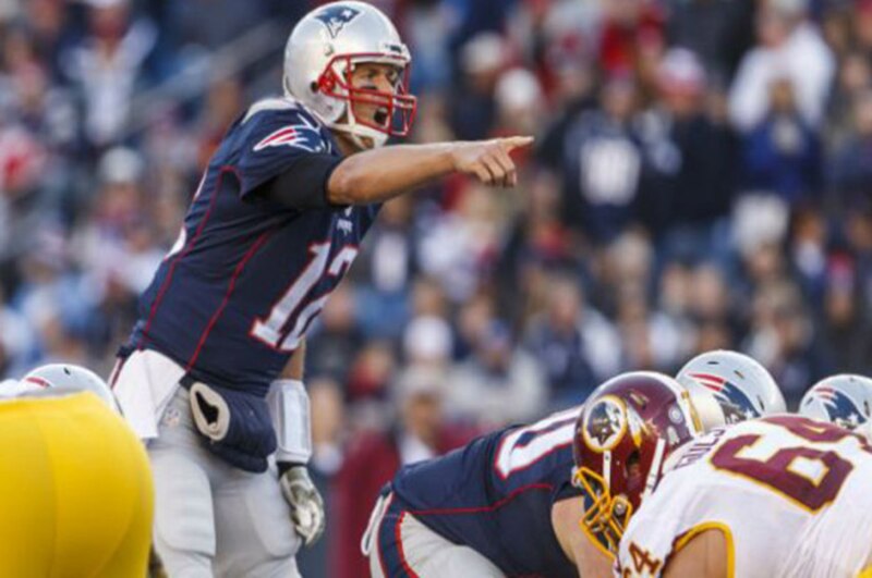 Tom Brady, el mariscal de campo de los New England Patriots, da instrucciones a su equipo durante un partido de fútbol americano.