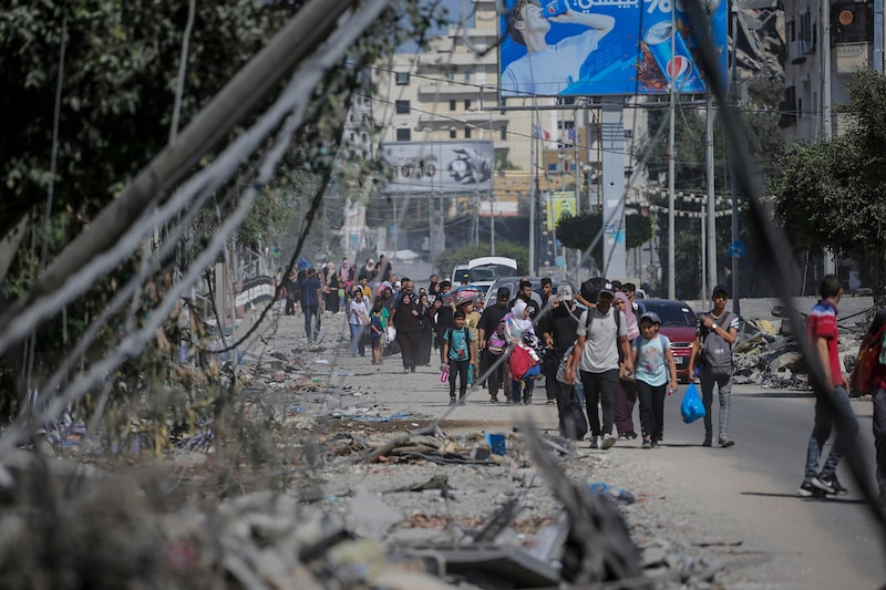 Familias desplazadas caminan por una calle destruida en Siria