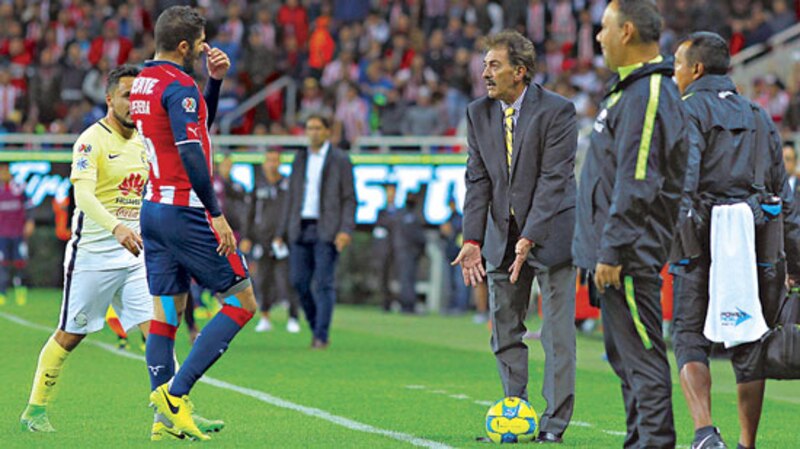 Miguel Herrera, director técnico del América, da instrucciones a sus jugadores durante un partido de fútbol.