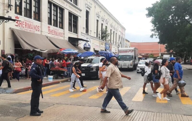 Multitud de personas cruza la calle en el centro de la ciudad