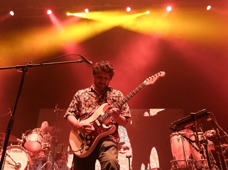 Un músico tocando la guitarra en un concierto