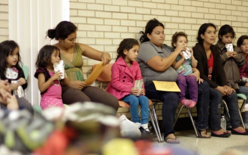 Madres migrantes esperan en un centro de detención
